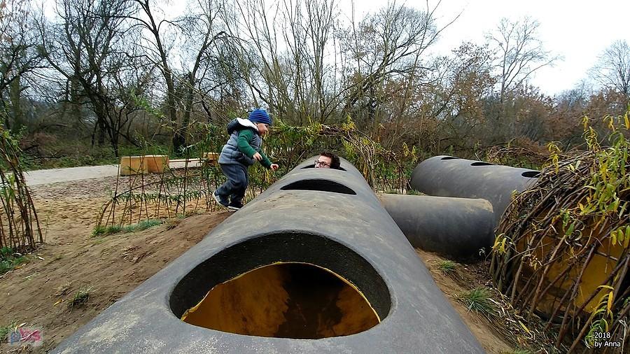 Dzieci bawią się w tunelach rurowych w parku