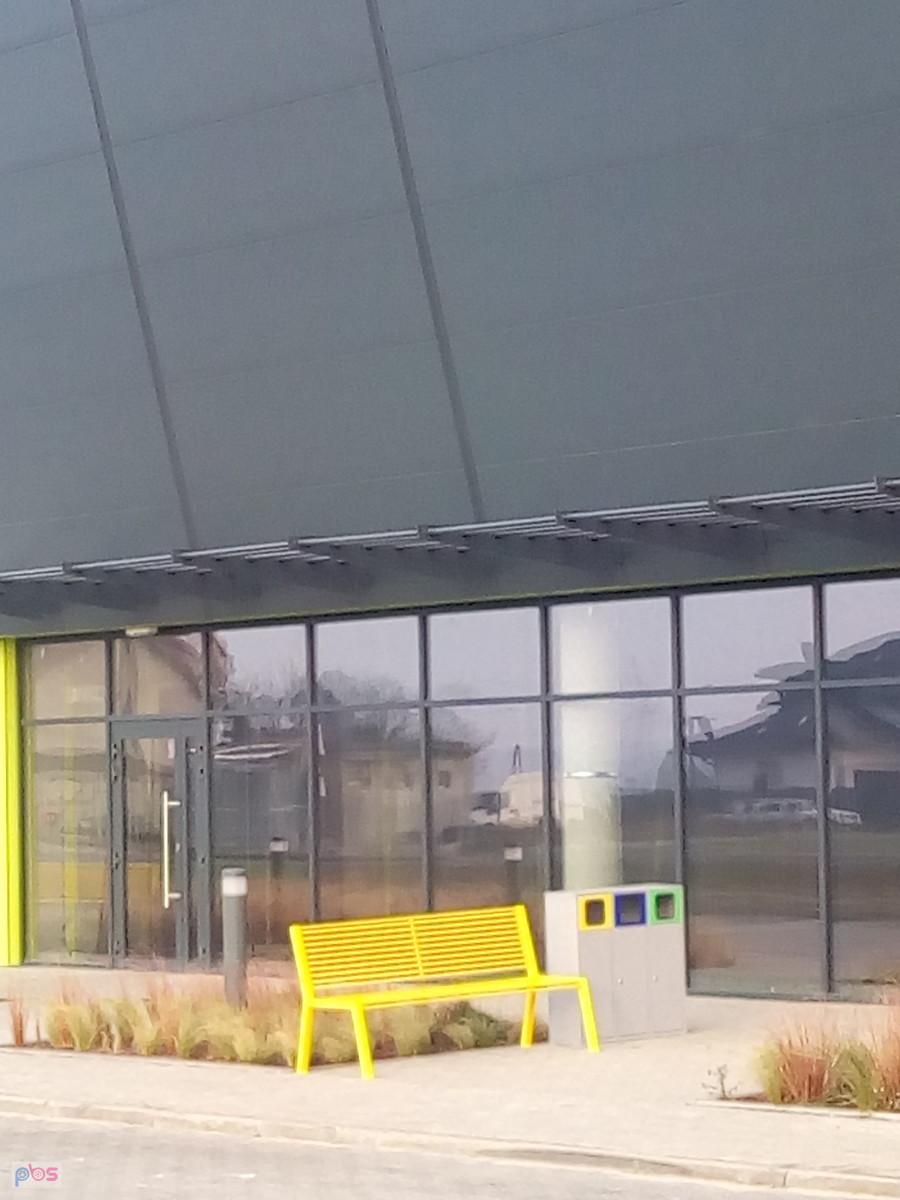 Ławeczka przed halą sportową w Kaputach. Może dla palących sportowców, skoro przy koszach na śmieci
