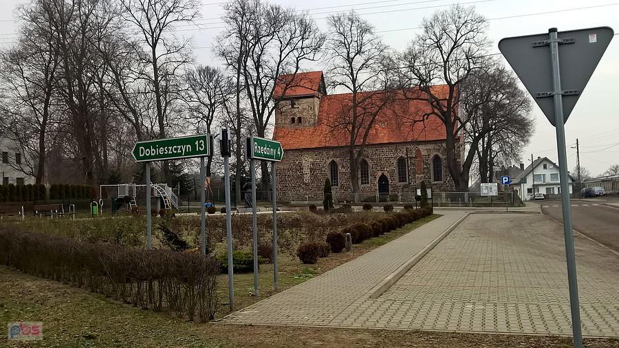 Centrum małej miejscowości Buk i drogowskazy.