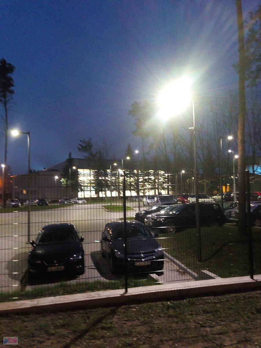 Parking przed akademikiem WAT, w tle budynek basenu