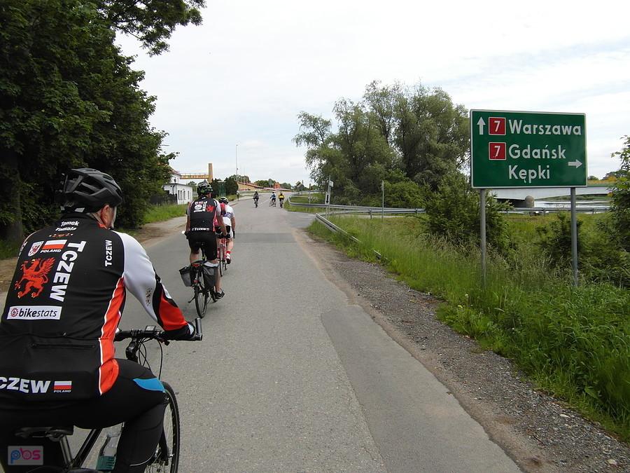 Grupa rowerzystów na wiejskiej drodze