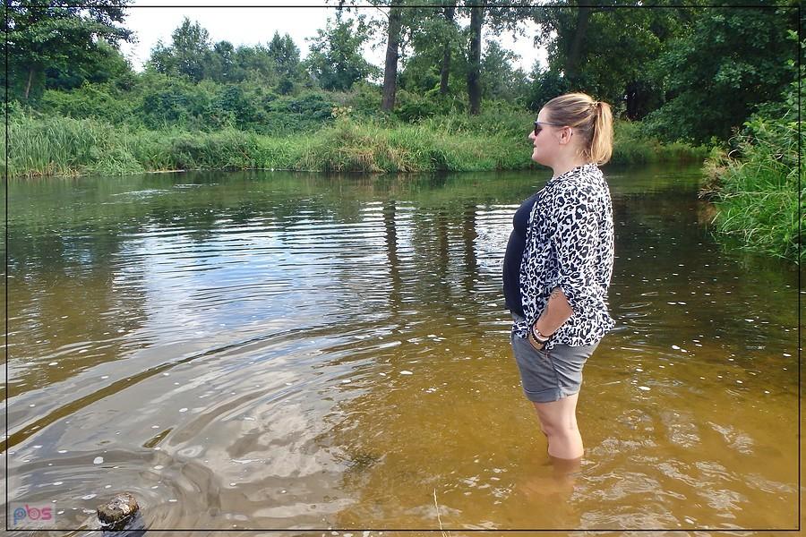 Justynka moczy nogi w rzece