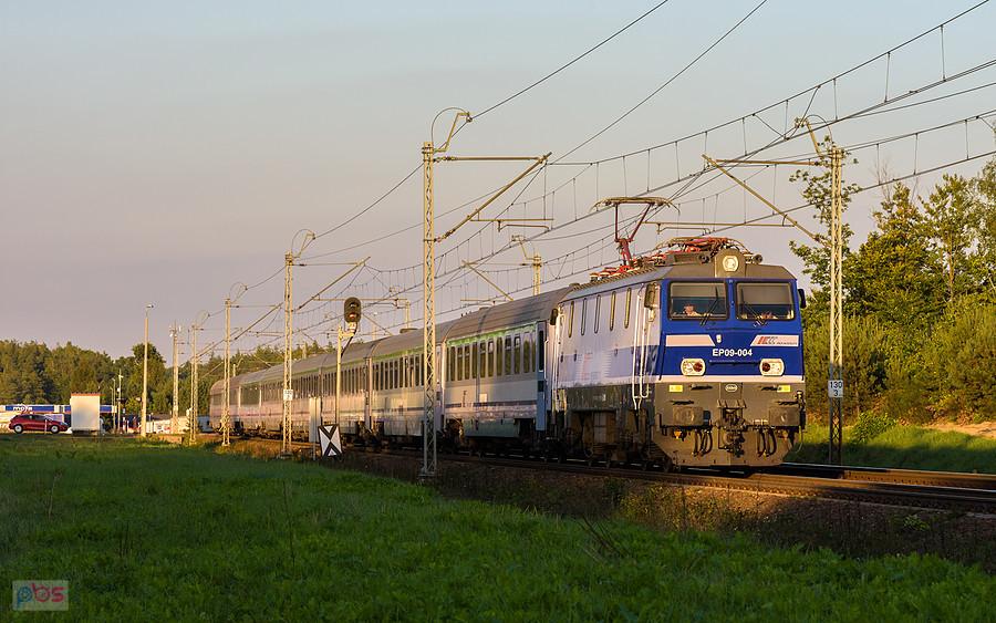 W ostatnich promieniach zachodzącego słońca EP09-004 na czele poc. IC 3700 "Siemieradzki" relacji: Przemyśl Główny - Poznań Główny wjeżdża do miejscowości Pietrzaki. Szlak: Blachownia - Herby Stare, linia D29-61.