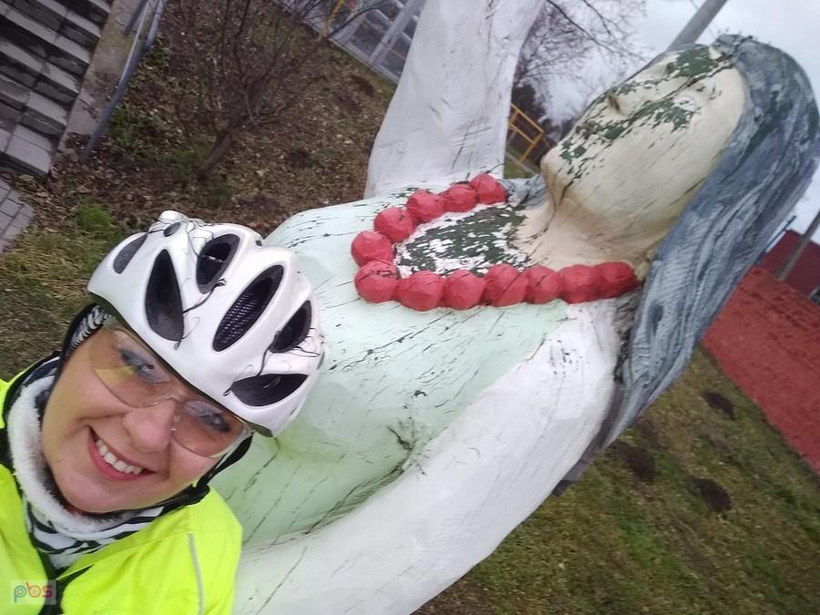 Rowerzystka przy rzeźbie Maryi
