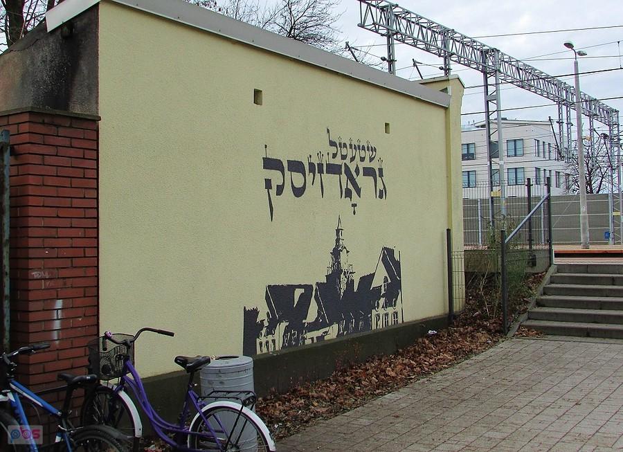 Grodzisk wita - napis powitalny w języku jidysz, przy stacji kolejowej