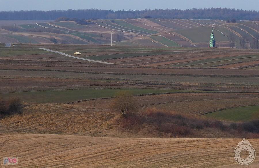 wieża kościoła w Sułoszowej wychylająca się zza pól i ostatniego podjazdu tej części trasy