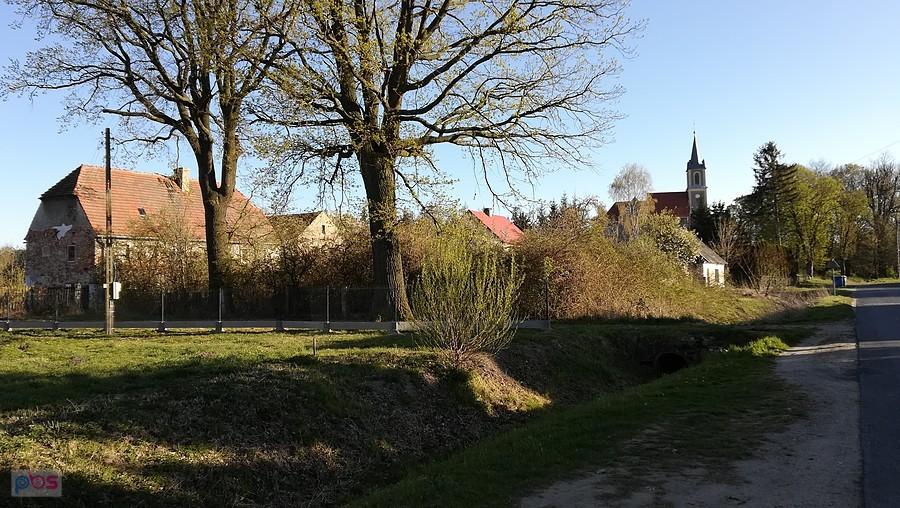 Widok na kościół i stare zabudowania w Paździornie