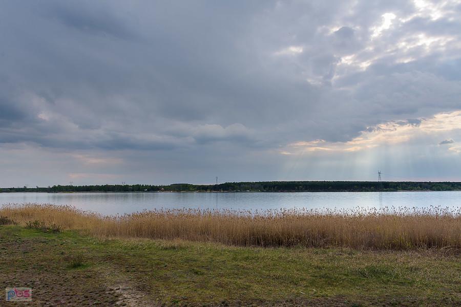 Ciemne chmury nad zalewem "Poraj" widziane z brzegu w miejscowości Masłońskie.