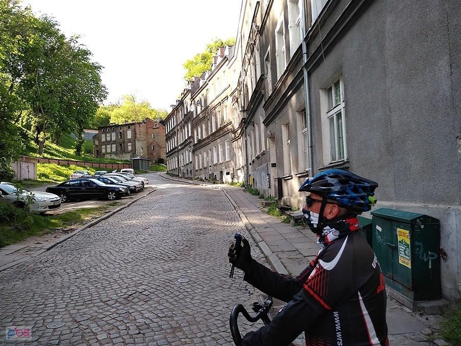 Rowerzysta na brukowanej ulicy w zabytkowej dzielnicy