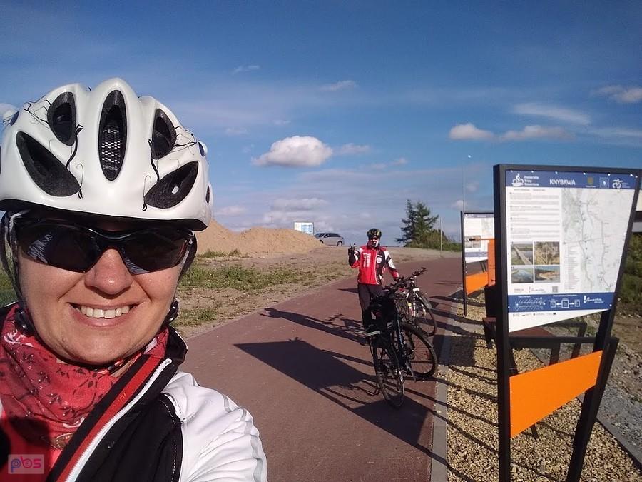Rowerzystka robi selfie na szlaku przy tablicy informacyjnej