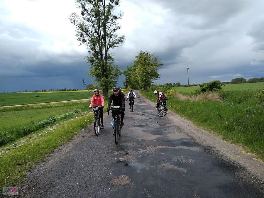 Grupa rowerzystów na wiejskiej drodze