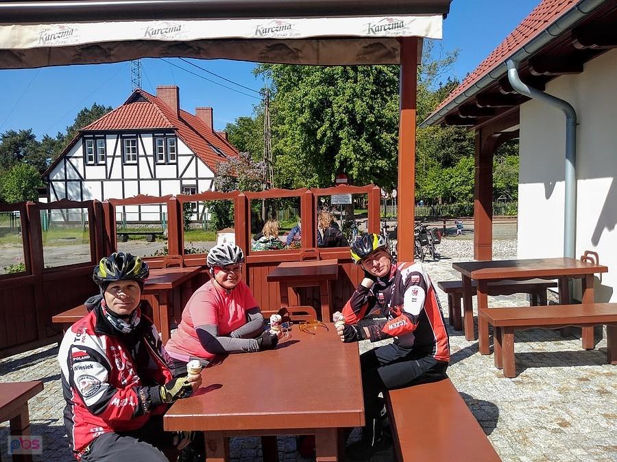 Grupa rowerzystów jedzących lody na zewnątrz