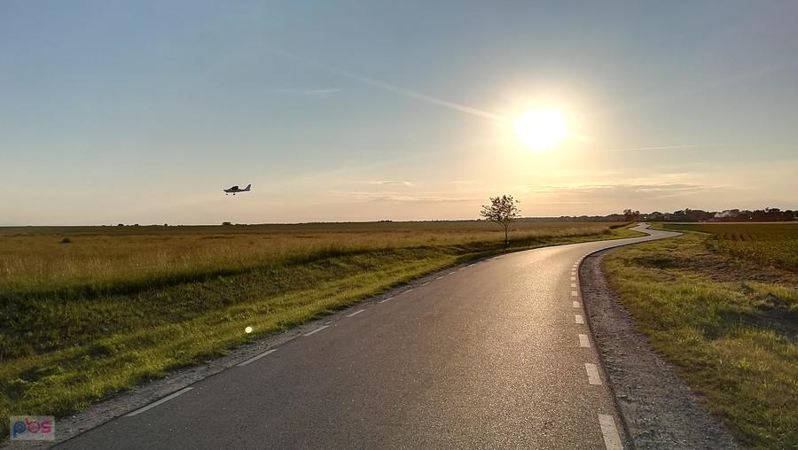 Lądująca awionetka w blasku wieczornego słońca