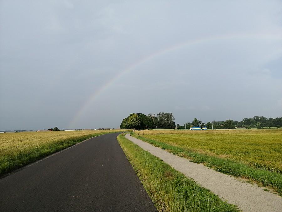 W oddali niewyraźna tęcza zwiastująca, że nadchodzi deszcz.