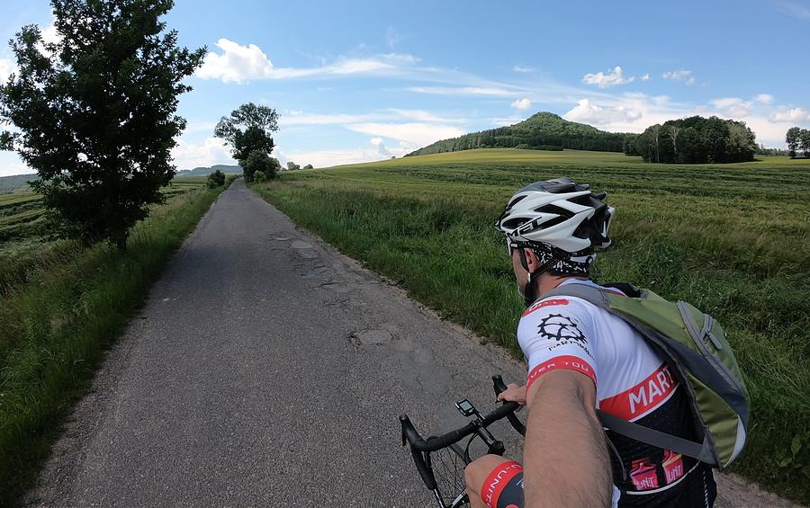 Na takich bocznych asfaltach to tylko pomykać. W tle dawny wulkan - Ostrzyca (501m)