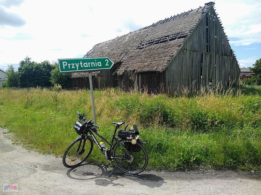 Rower trekkingowy przed starą drewnianą stodołą