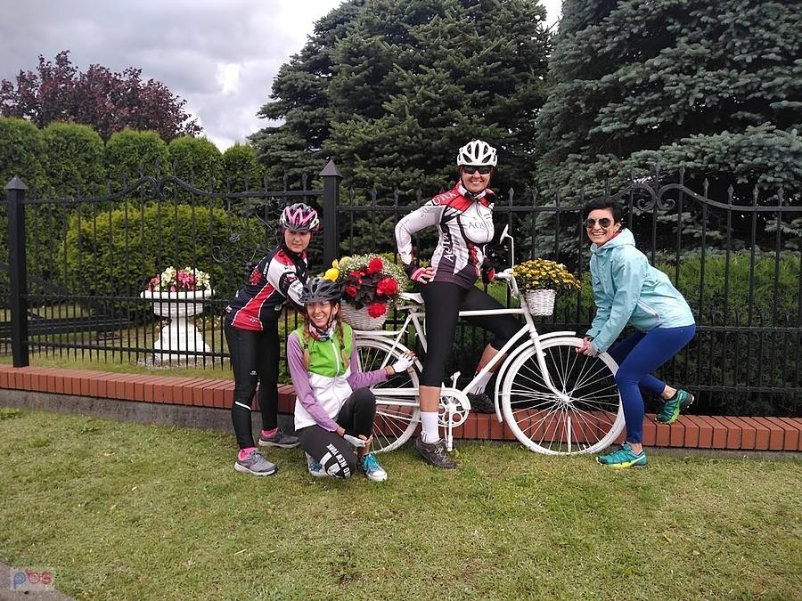 Cztery rowerzystki przy białym rowerze