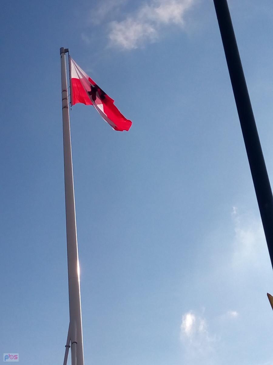 Flaga na maszcie na rondzie Radosława. Na fladze znak Polski Walczącej