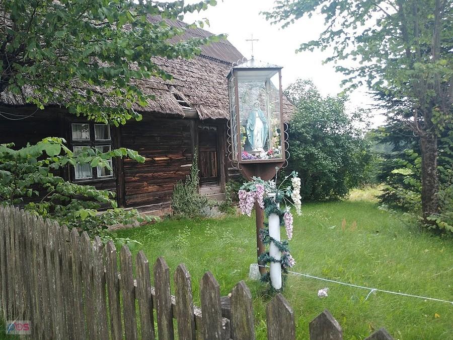 Kapliczka z figurą Matki Bożej przy drewnianej chacie