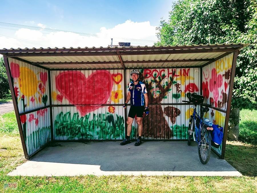 Kolarz na przystanku z graffiti