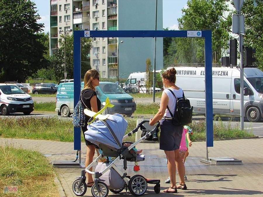 W upalny dzień przy zraszaczu