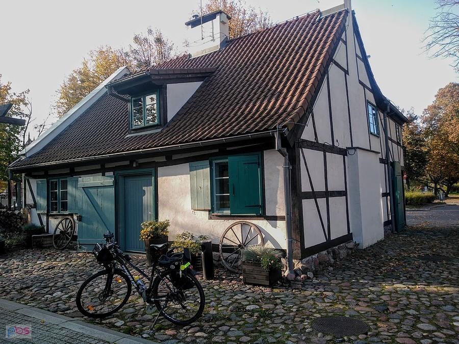 Dom szachulkowy przy brukowanej ulicy