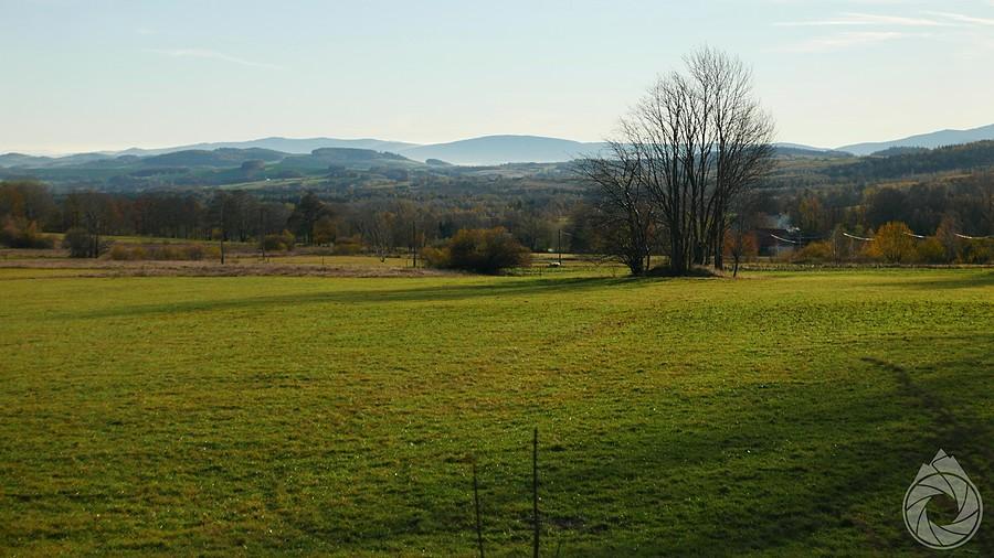 jesienno-zazielenione pola i spojrzenie na Karkonosze z przełęczy nad Rębiszowem