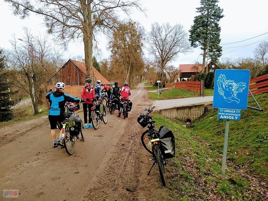 Grupa rowerzystów na wiejskiej drodze