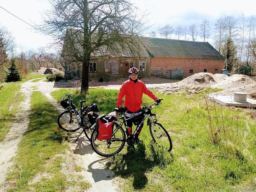 Rowerzysta z sakwami na wiejskiej drodze