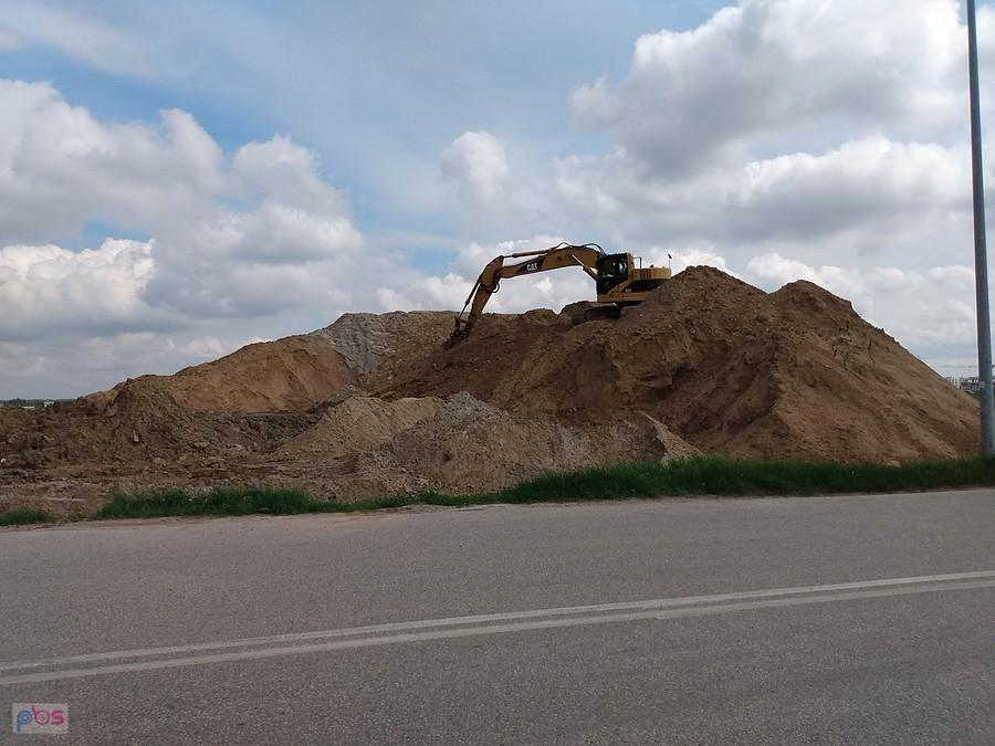 Koparka na górze piachu.