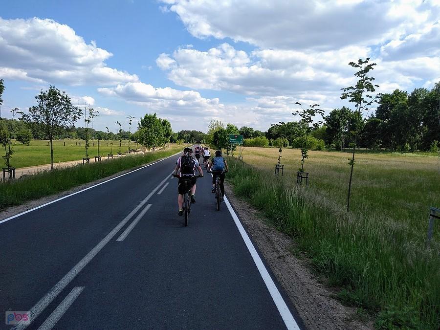 Grupa rowerzystów na wiejskiej drodze