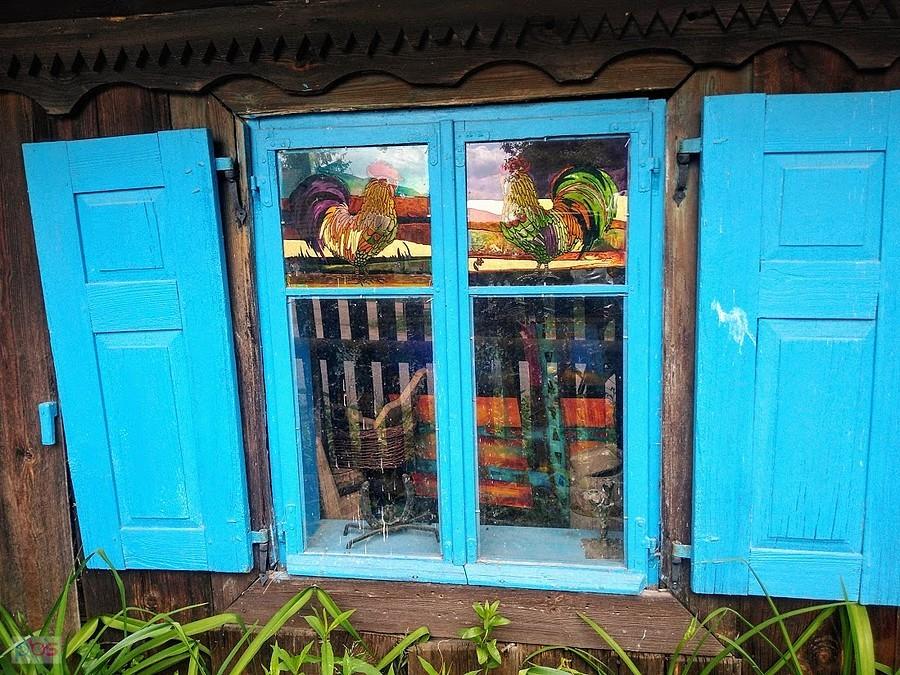 Niebieskie okno z malowanymi kogutami