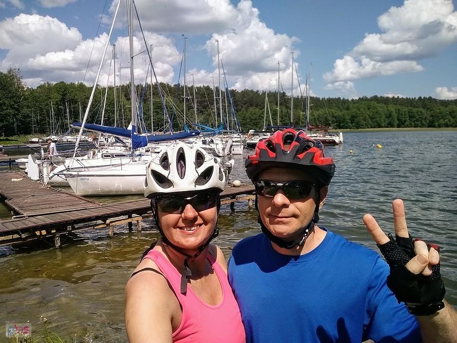 Dwie osoby na rowerach przy marinie na Mazurach