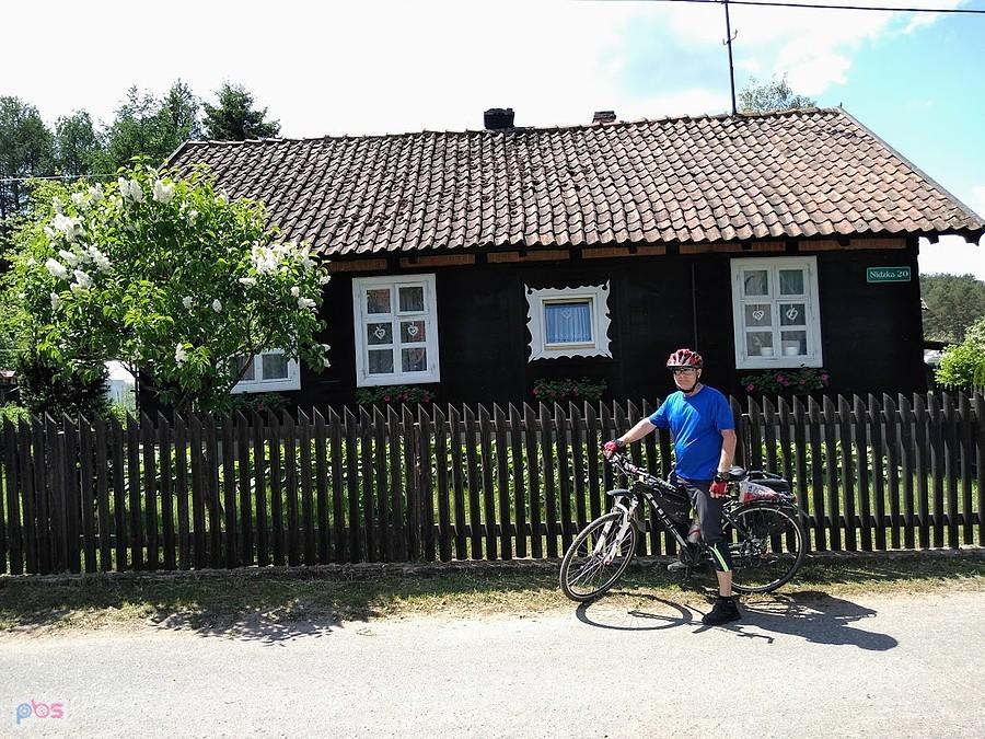 Rowerzysta przed wiejskim domem
