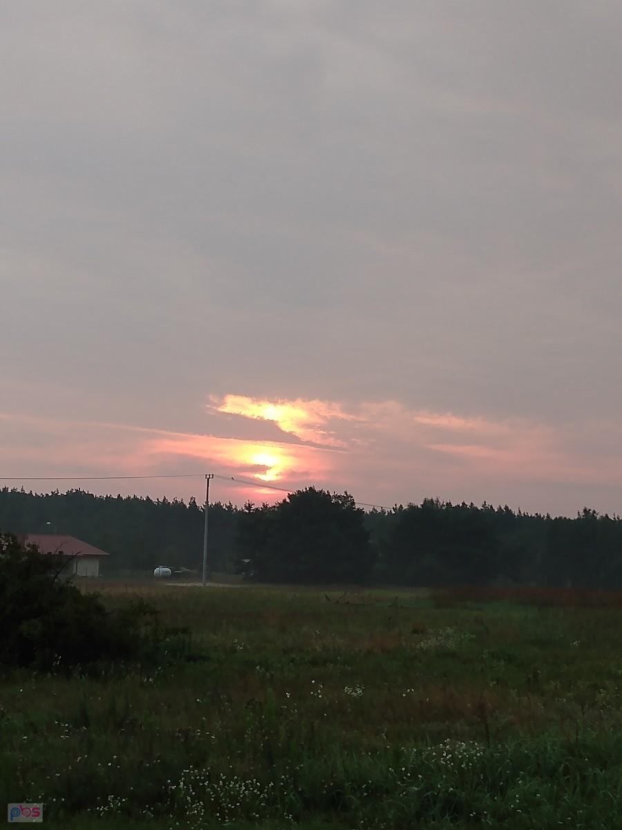 Słońce wschodzi na zachmurzonym niebie