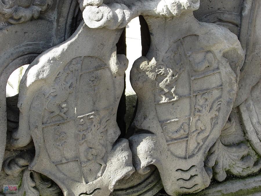Tarcze herbowe przy figurze morowej należą zapewne do jej fundatorów - Tannerów