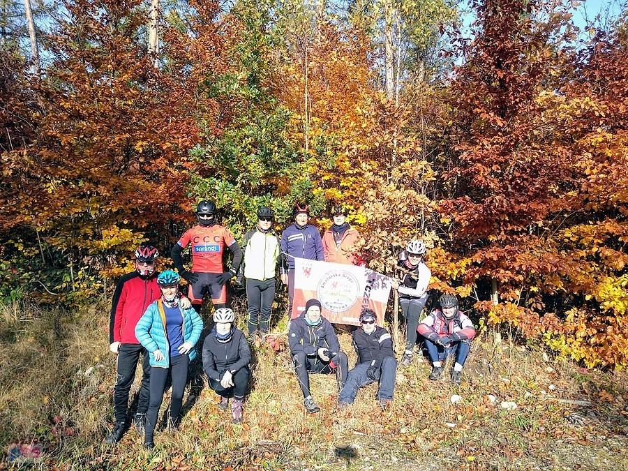 Grupa rowerzystów na jesiennej leśnej polanie
