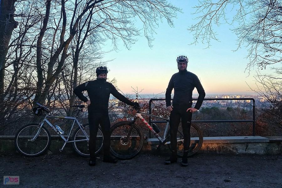 Dwóch rowerzystów na tle panoramy miasta