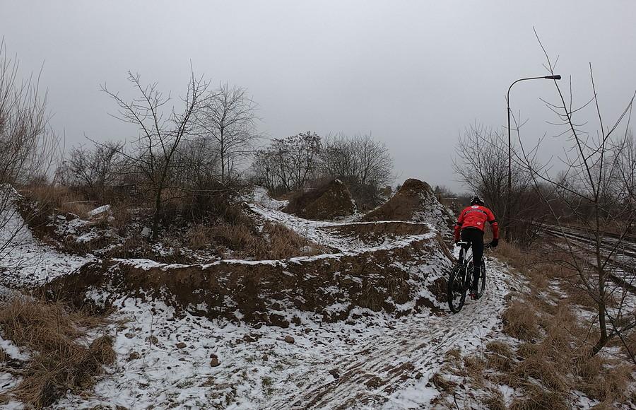 Rowerzysta BMX na torze ziemnym w zimowej scenerii