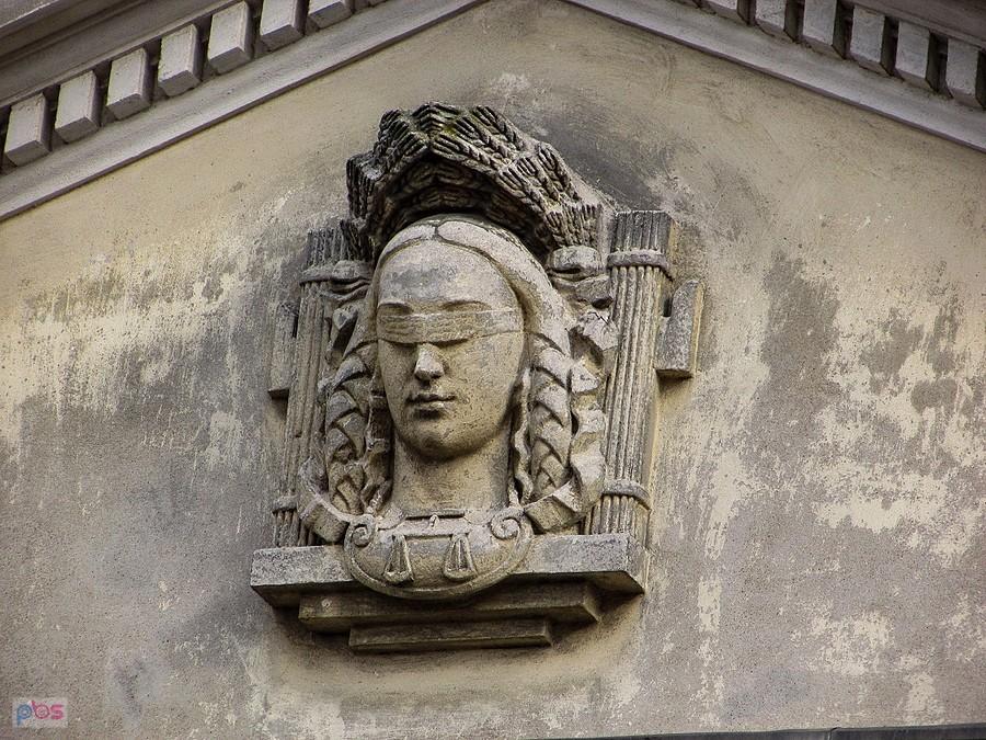 Głowa Temidy w tympanonie pałacu