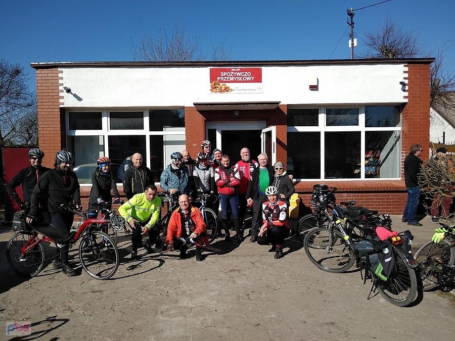 Grupa rowerzystów przed budynkiem