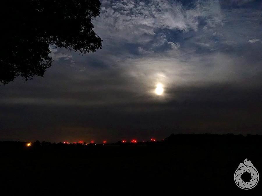 pełnia za chmurami, w oddali wiatraki dolnośląskie