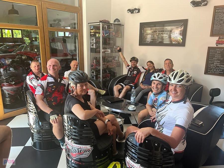 Grupa rowerzystów w muzeum samochodowym