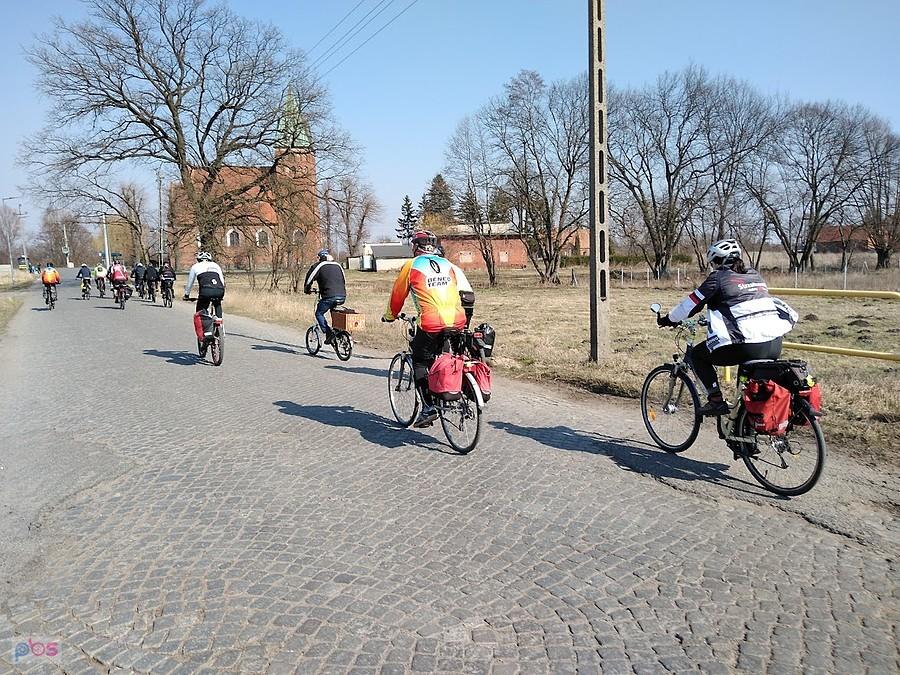 Grupa rowerzystów na wiejskiej drodze