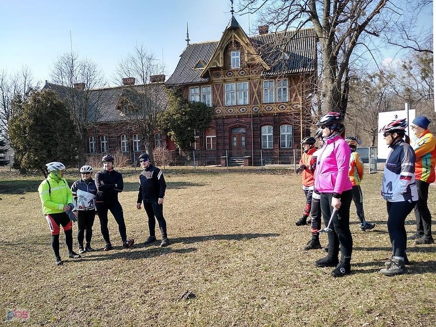 Grupa rowerzystów przed zabytkowym budynkiem