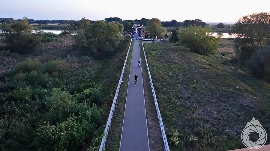 ostatni rowerzyści zjeżdżają z dawnego mostu kolejowego z Niemiec do Siekierek