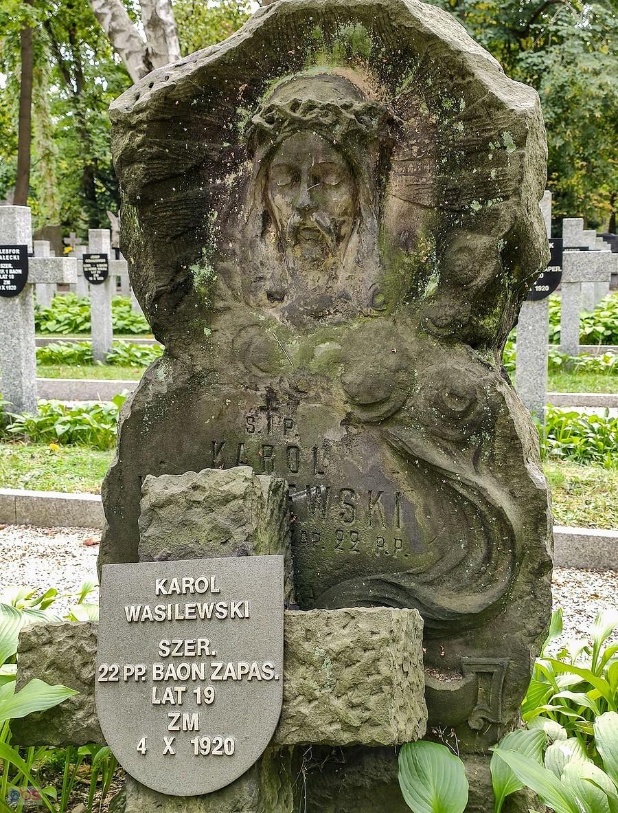 Pomnik nagrobny wśród prostych żołnierskich krzyży