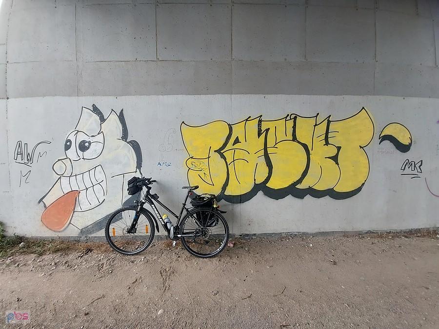 Rower przy graffiti na murze