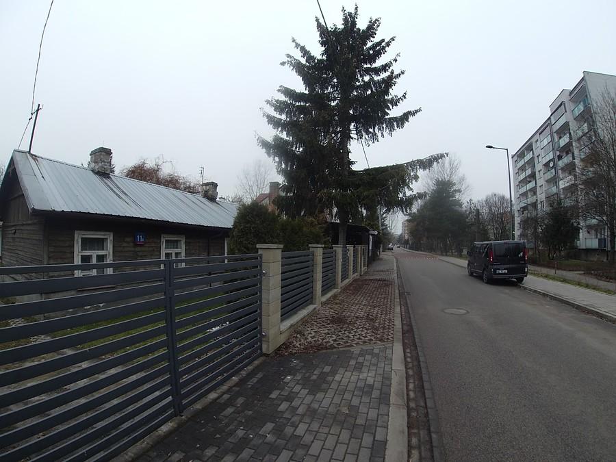 Ulica osiedlowa z chodnikiem i ogrodzeniami