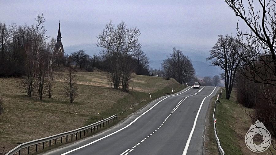 droga na południe, w stronę gór, ze strzelistą wieżą kościoła w Równem